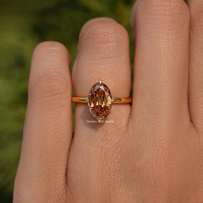 Champagne oval moissanite solitaire ring with slim gold-tone band and center stone