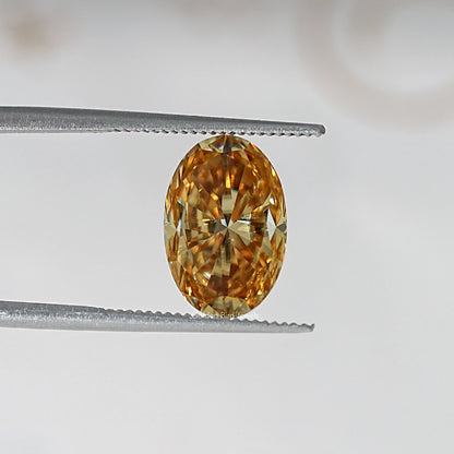 Oval champagne moissanite loose stone held in tweezers, bright golden center