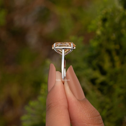 Oval champagne moissanite ring viewed from side, sterling silver band and prongs