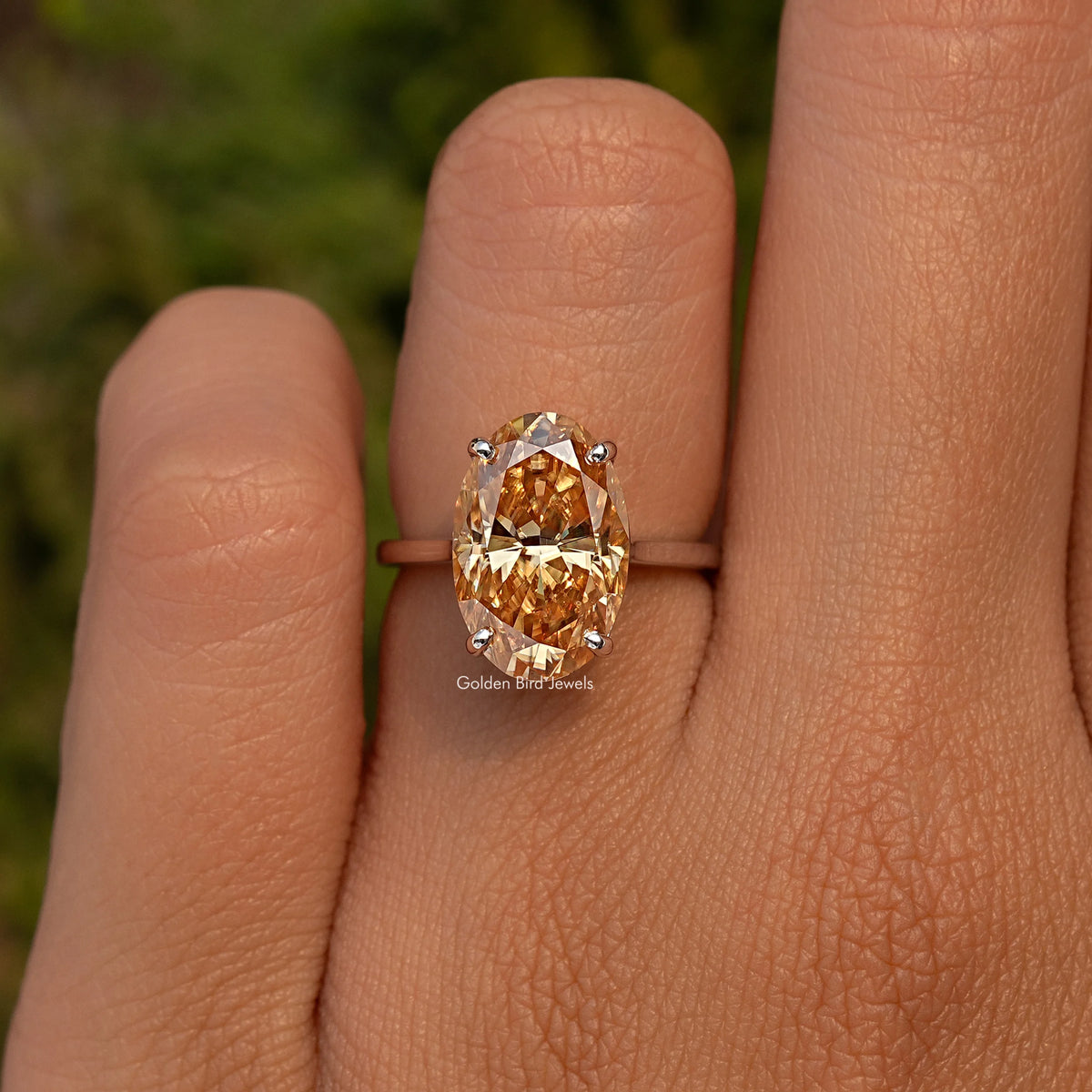 Oval champagne moissanite ring close-up with sterling silver setting and prongs