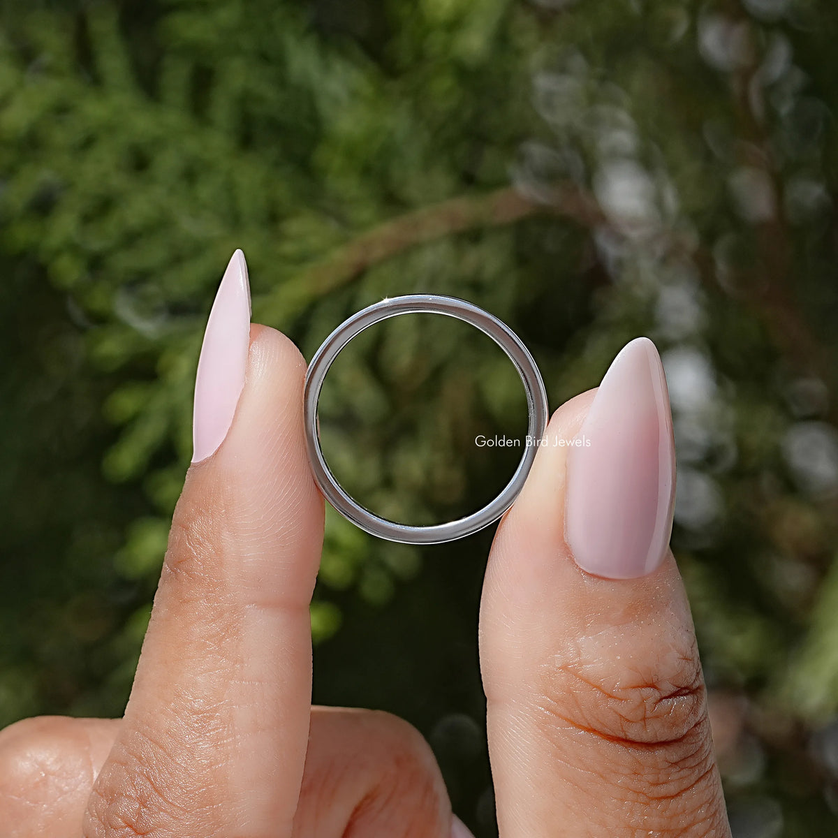 Round-stone channel-set eternity ring shown from the front, silver-tone band