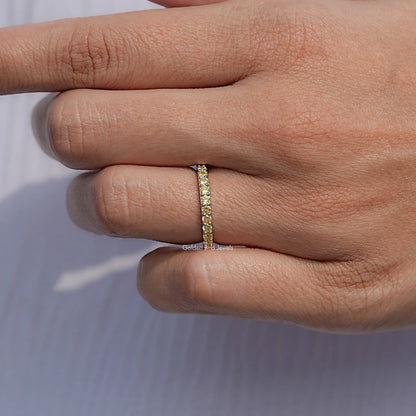 Gold-tone eternity ring with round yellow stones, band close-up on finger