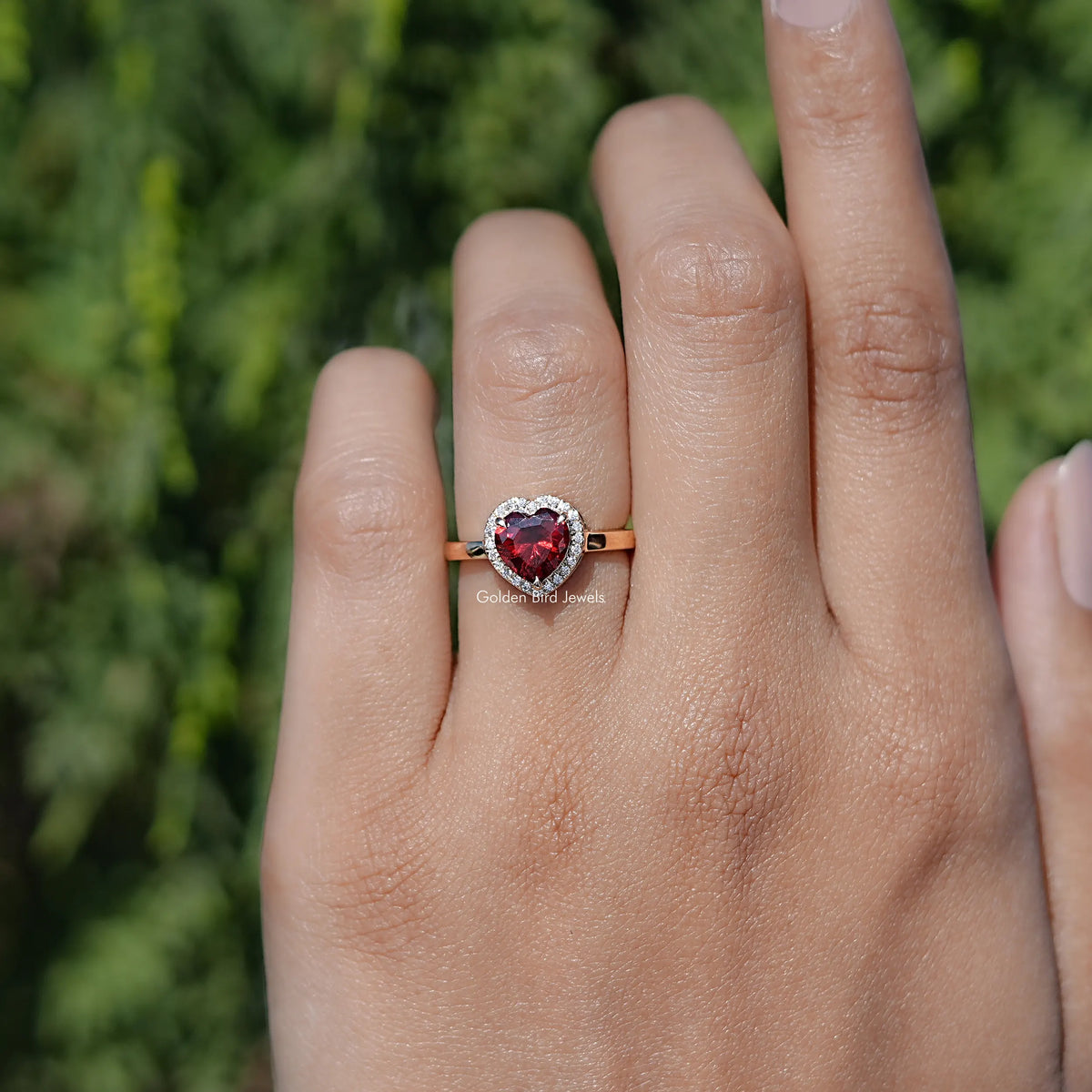 In finger front view of Red Ruby Heart engagement ring 
