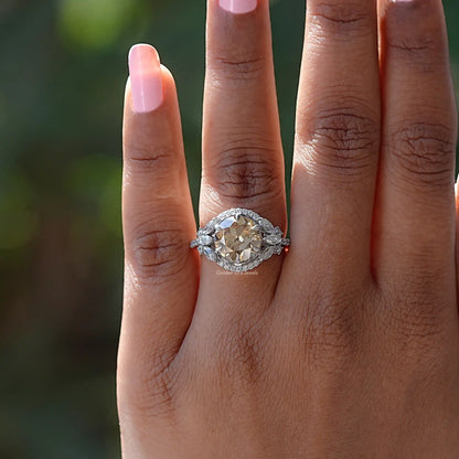 Silver halo cluster ring with round champagne center stone on hand close-up