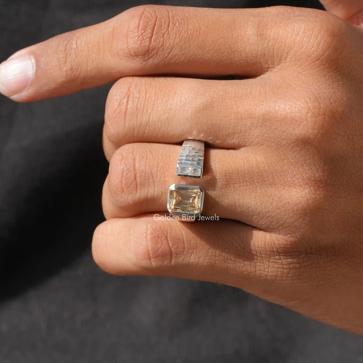 Open cuff two-stone ring close-up on finger, clear and amber square stones, split band
