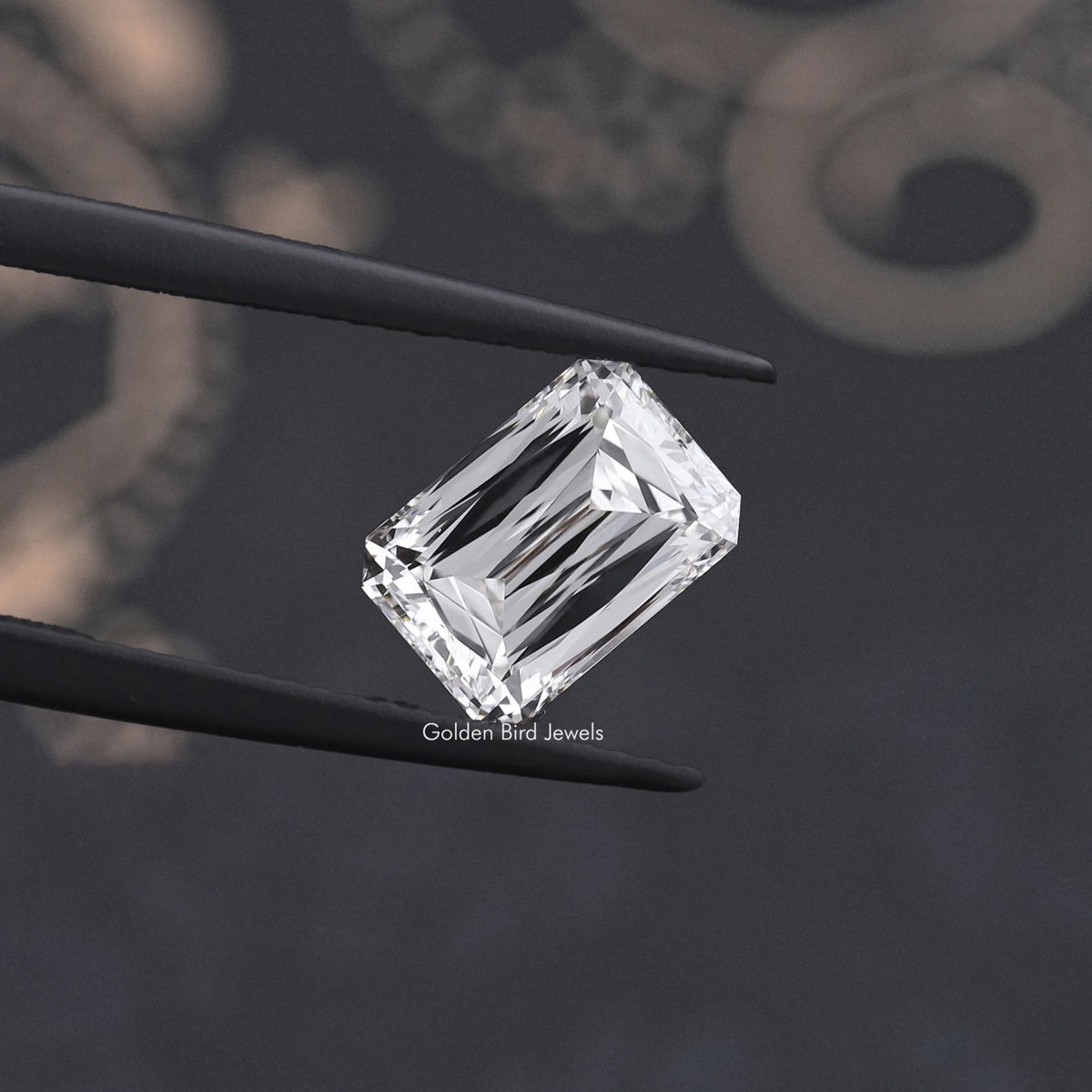 Square emerald-cut lab-grown diamond held between black tweezers, side facet detail