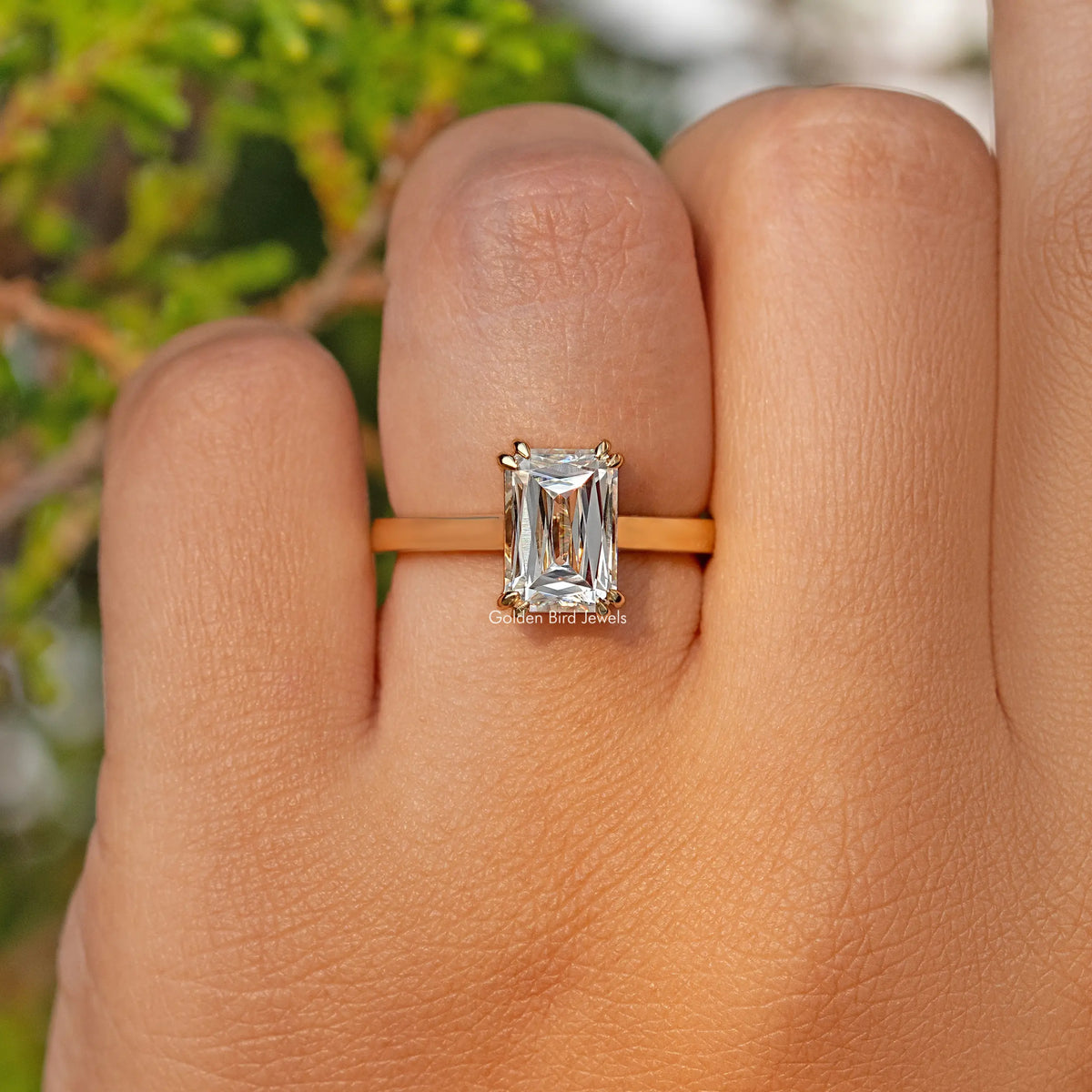 Moissanite solitaire engagement ring with rectangular stone, slim band on finger