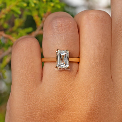 Moissanite solitaire engagement ring with rectangular stone, slim band on finger