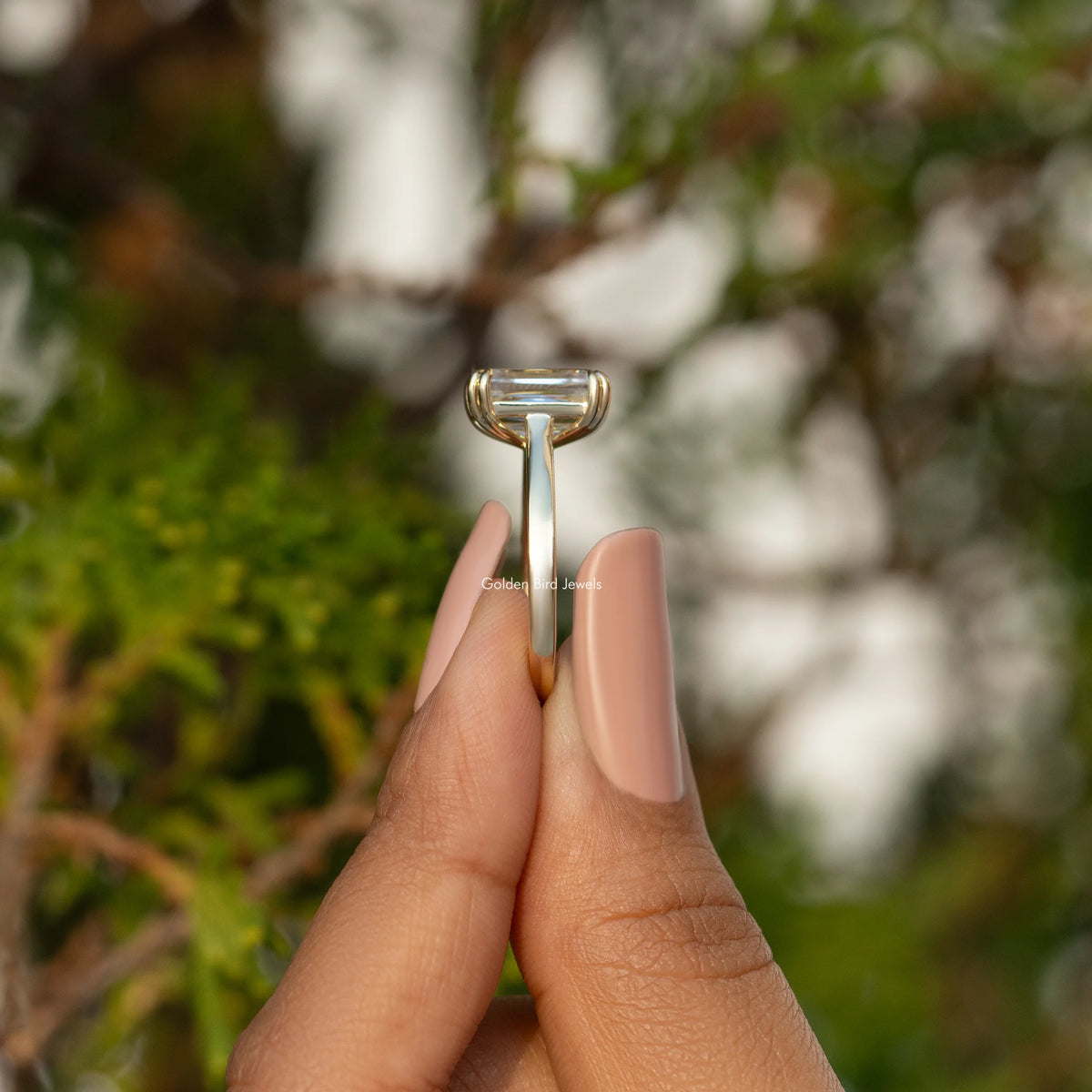 Moissanite solitaire engagement ring underside view with claw prongs, gold-tone band