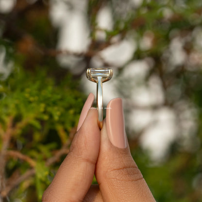 Moissanite solitaire engagement ring underside view with claw prongs, gold-tone band