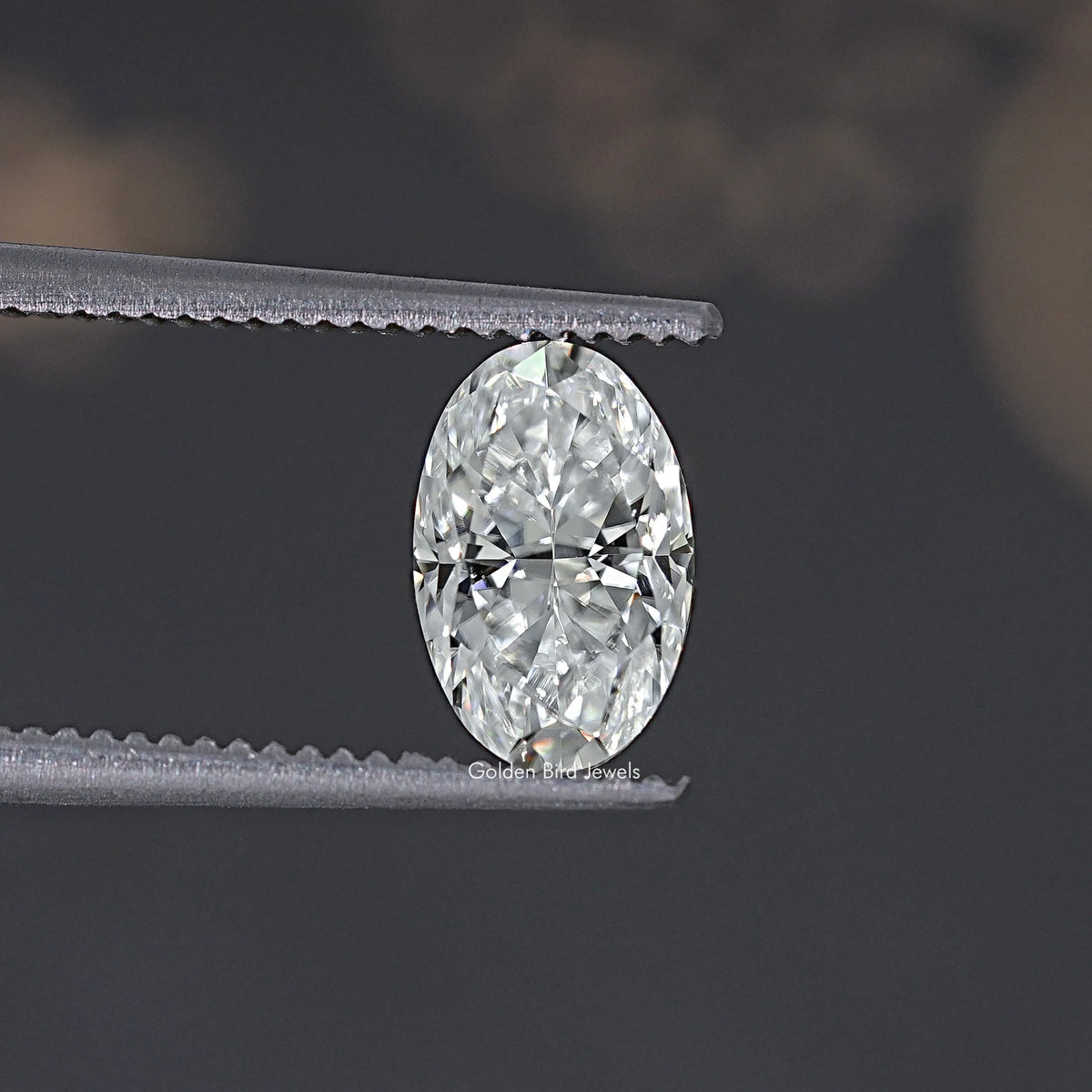 Oval crushed ice moissanite gemstone, clear brilliant facets held by tweezers