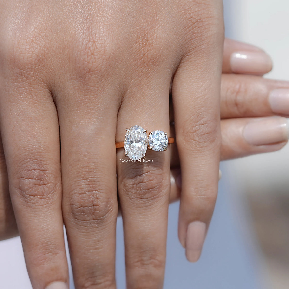 In front finger View Of Oval And Round Cut Moissanite Toi Et Moi Ring