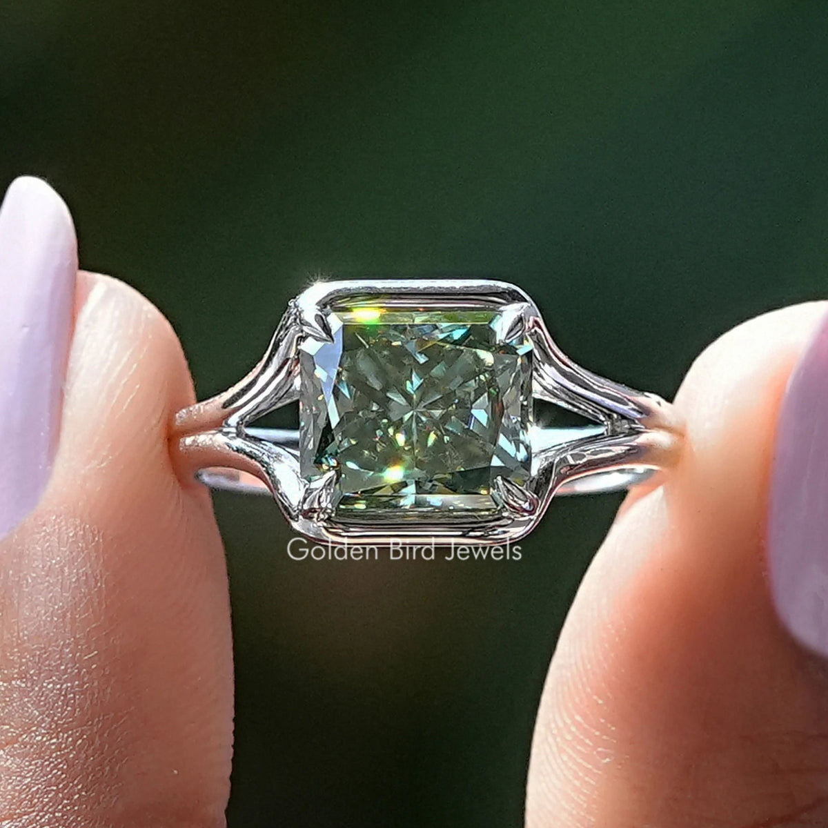 Silver engagement ring with emerald-cut center stone and side scroll prongs