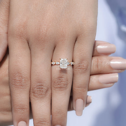 Silver-tone radiant-cut halo ring on finger with small round side stones.