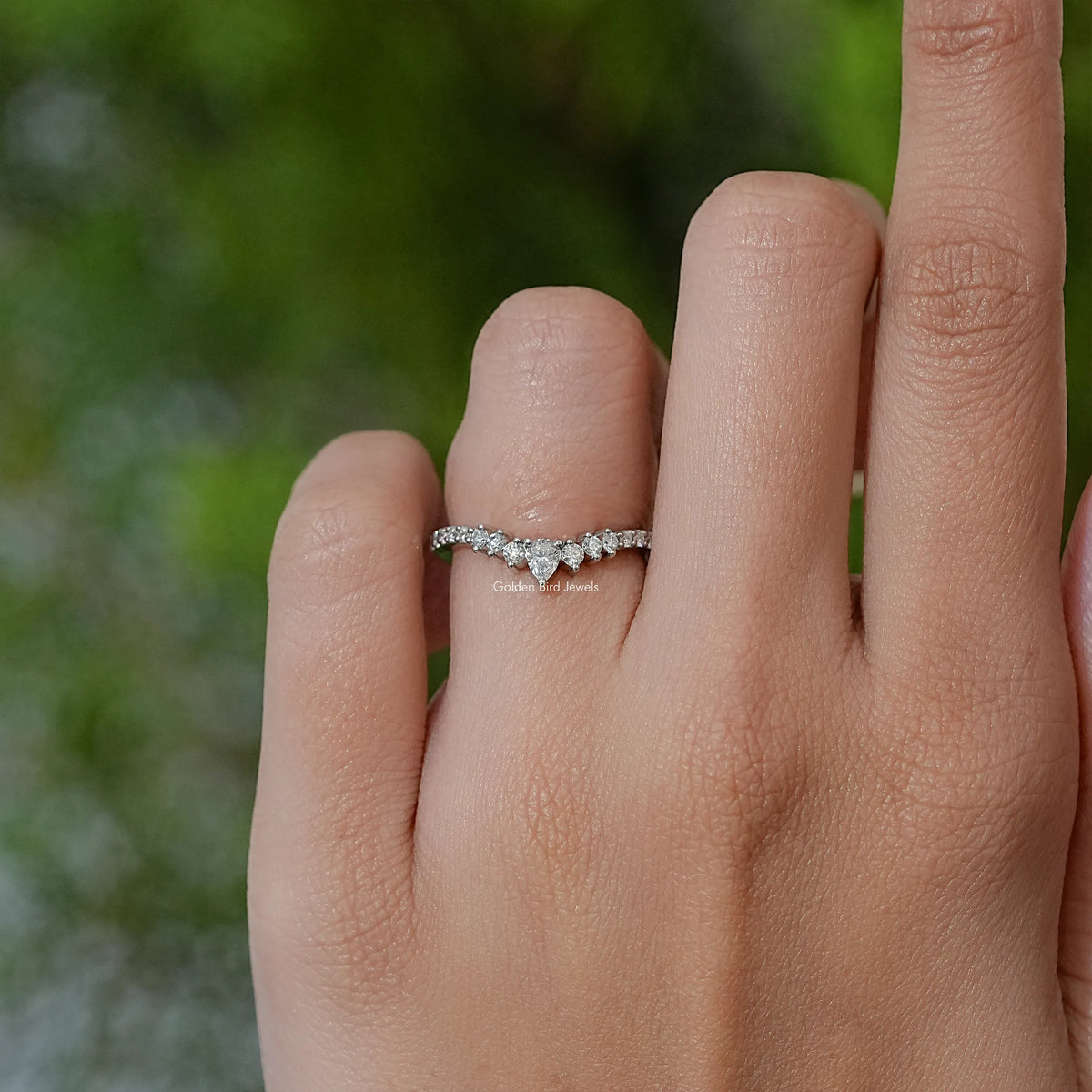 Silver chevron eternity band ring with pear-cut white moissanite stones on hand
