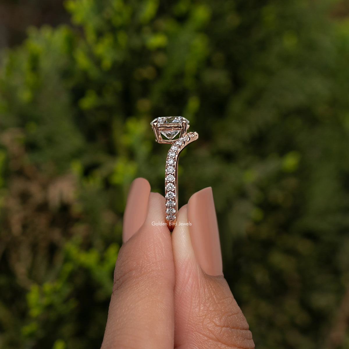 Curved accent engagement ring with round-cut center stone and pavé band