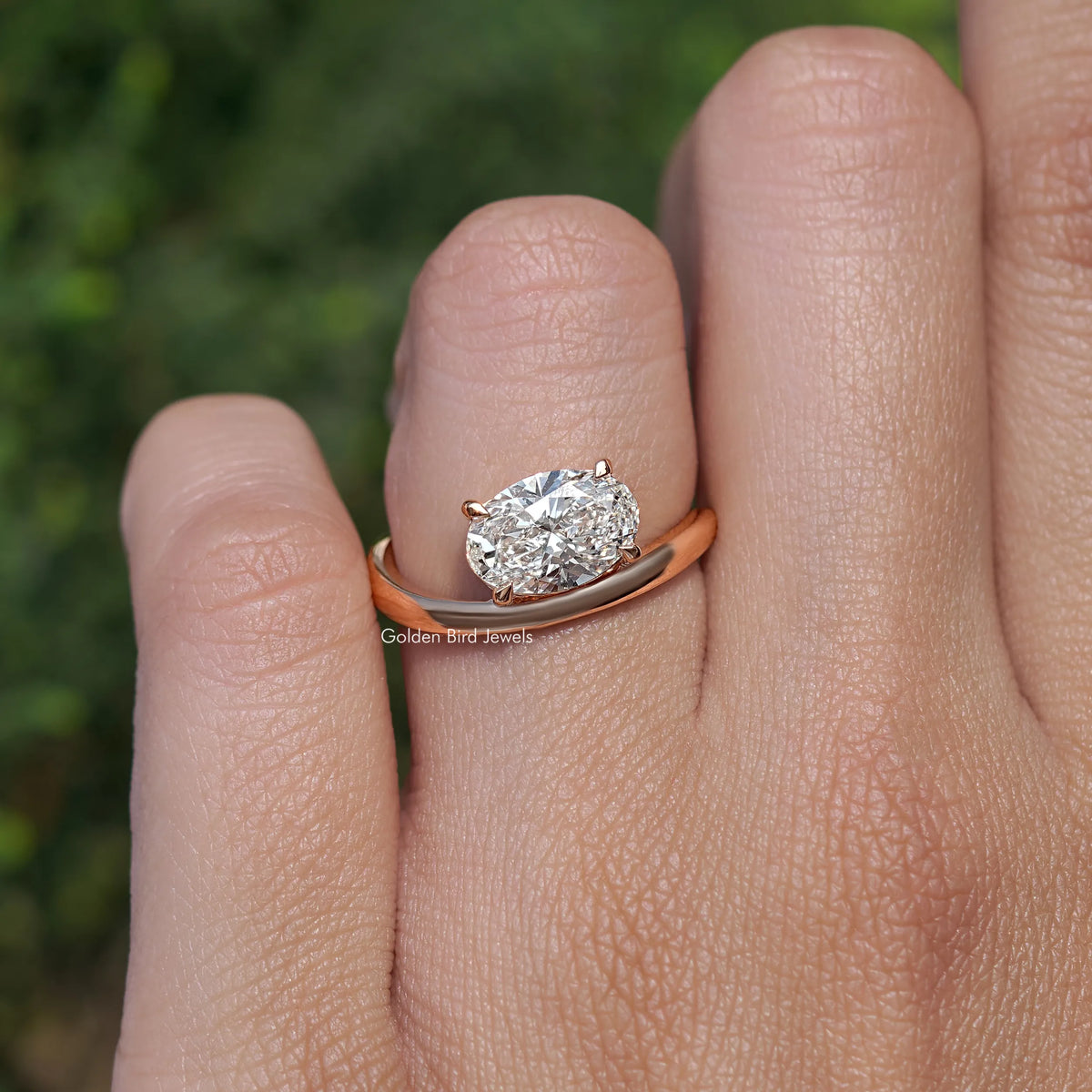 Oval solitaire diamond ring with rose-gold curved band and prong-set center stone