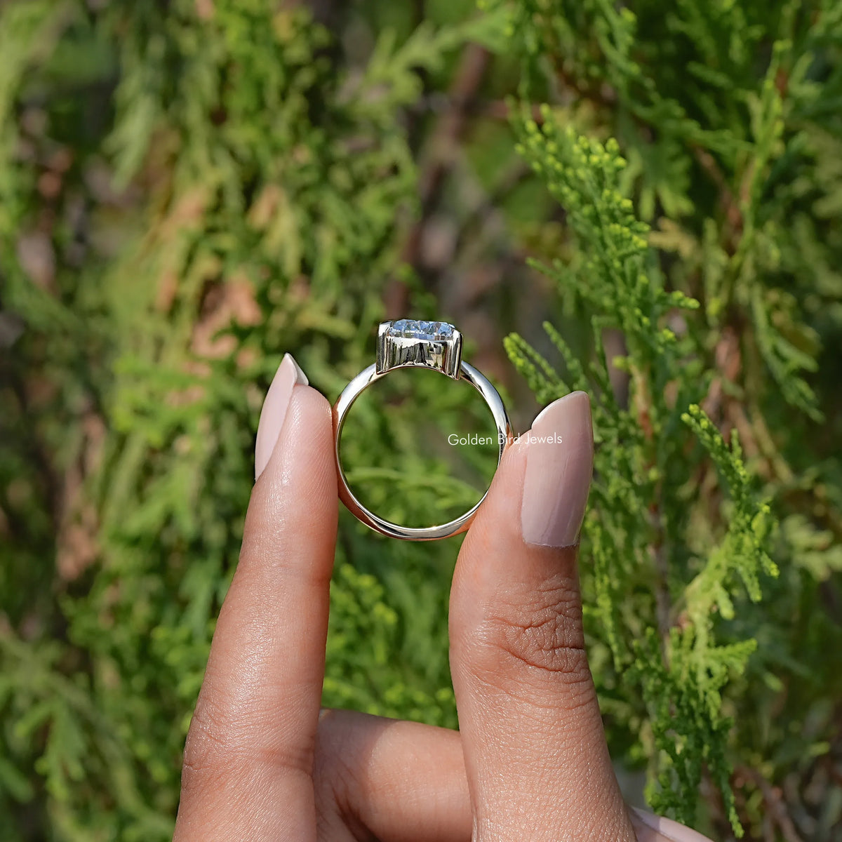 Back View of Pear Cut Curved V Shaped Solitaire Ring In two fingers