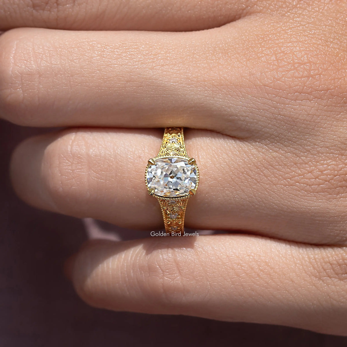 Gold cushion-cut moissanite ring with halo and filigree side details