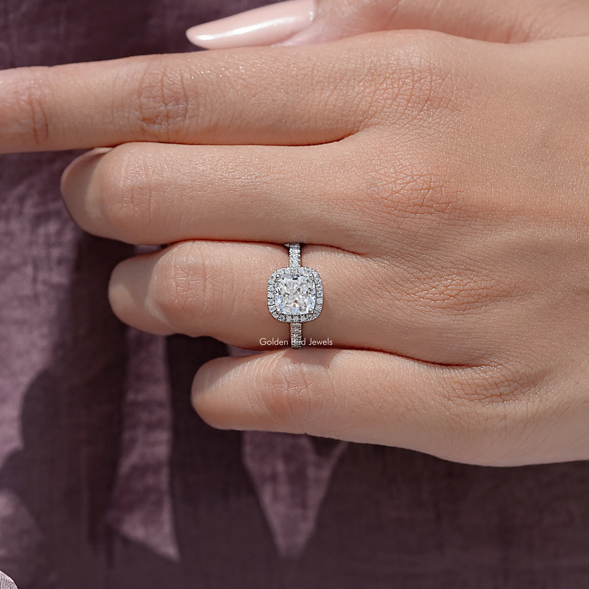 Cushion-cut moissanite halo ring on hand, sterling silver with small side stones