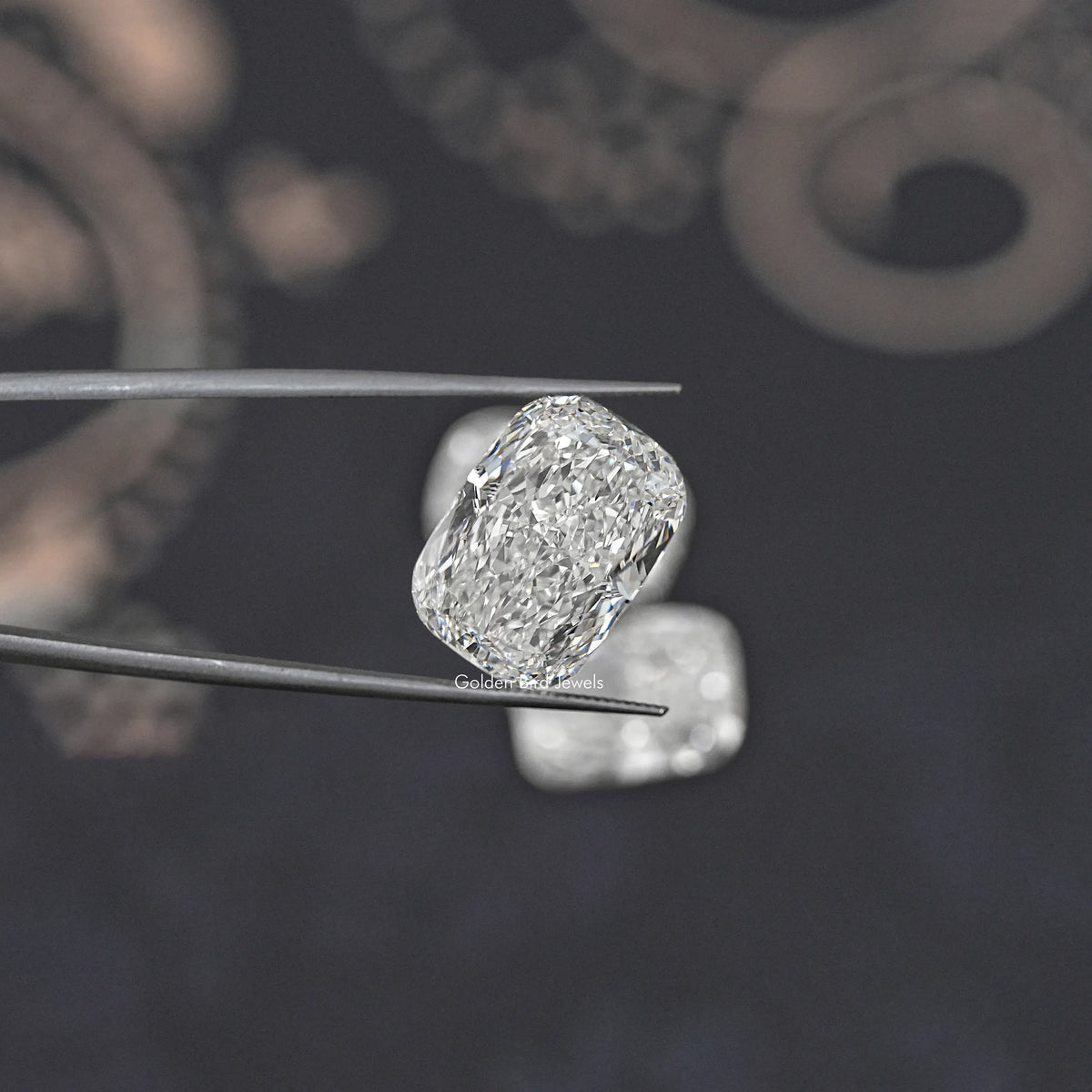 Elongated cushion-cut loose diamond on metal tweezers, faceted