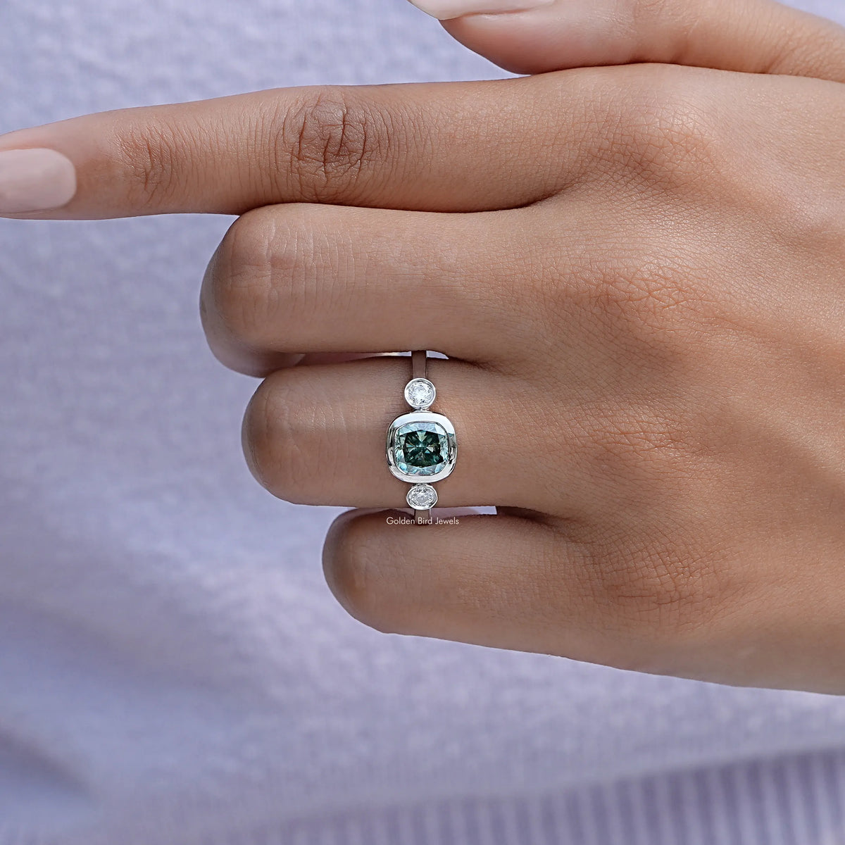 Three-stone engagement ring with cushion-cut moissanite center and side stones