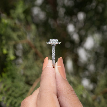 Silver-tone cushion-cut halo ring with tall prong setting, shown on finger