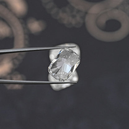 Elongated cushion-cut loose diamond on metal prongs, faceted