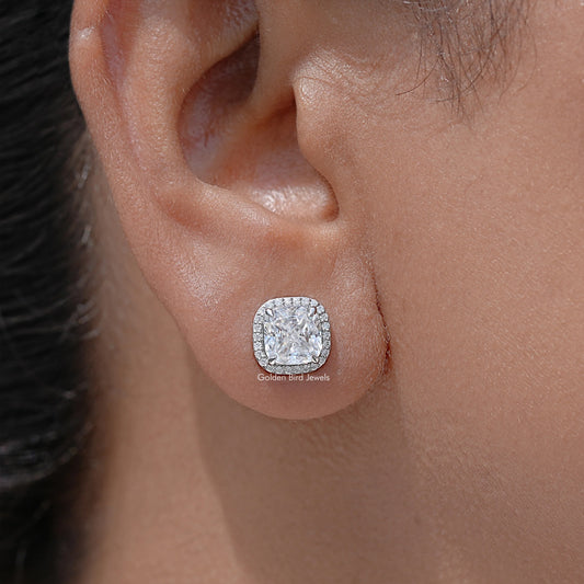 Cushion-cut halo stud earrings on ear, sparkling square center stones