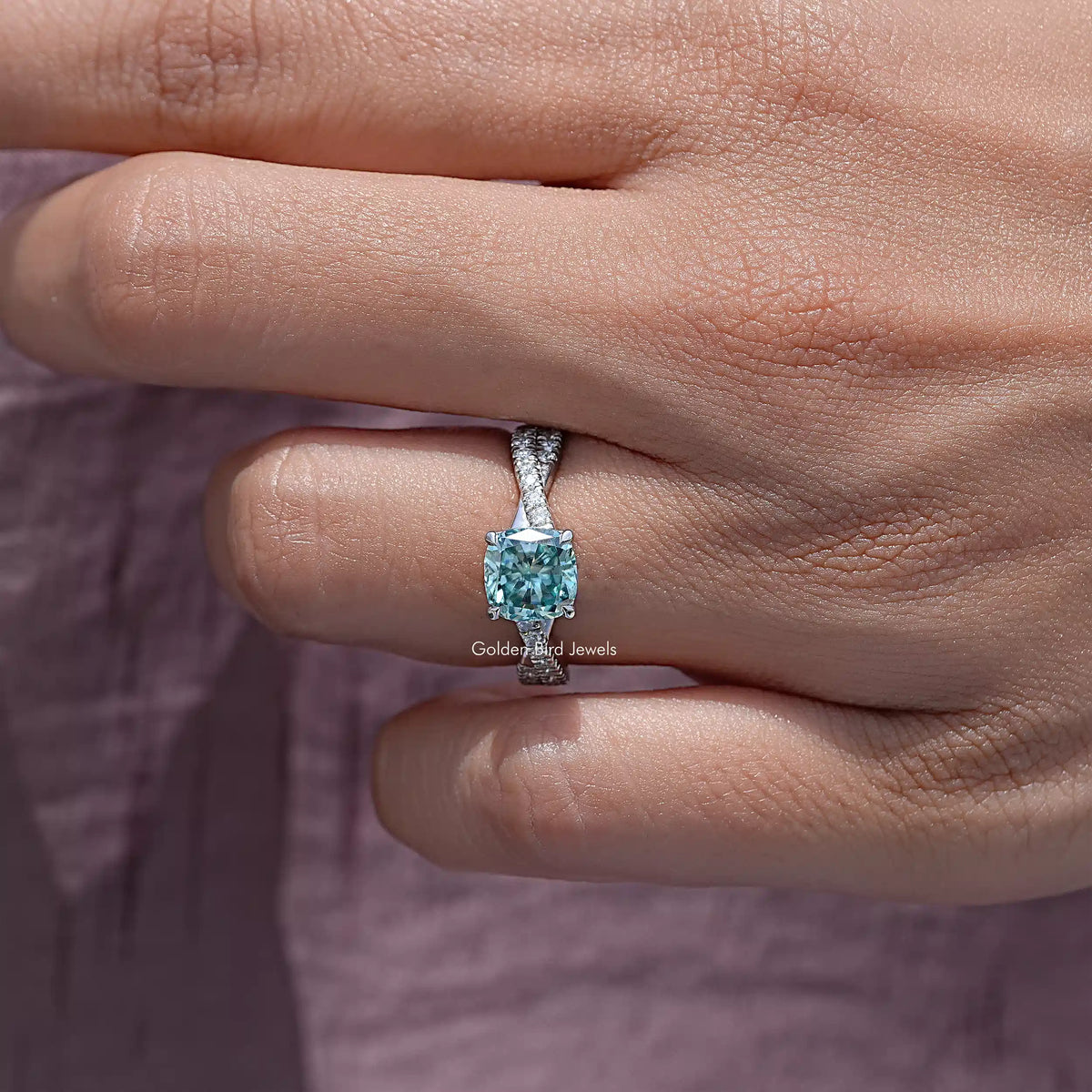 Cushion moissanite twisted accent engagement ring on hand