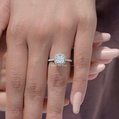 Cushion-cut moissanite halo ring with pavé band on a hand