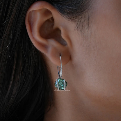 Sterling silver drop earrings with emerald-green cushion-cut moissanite, close to ear