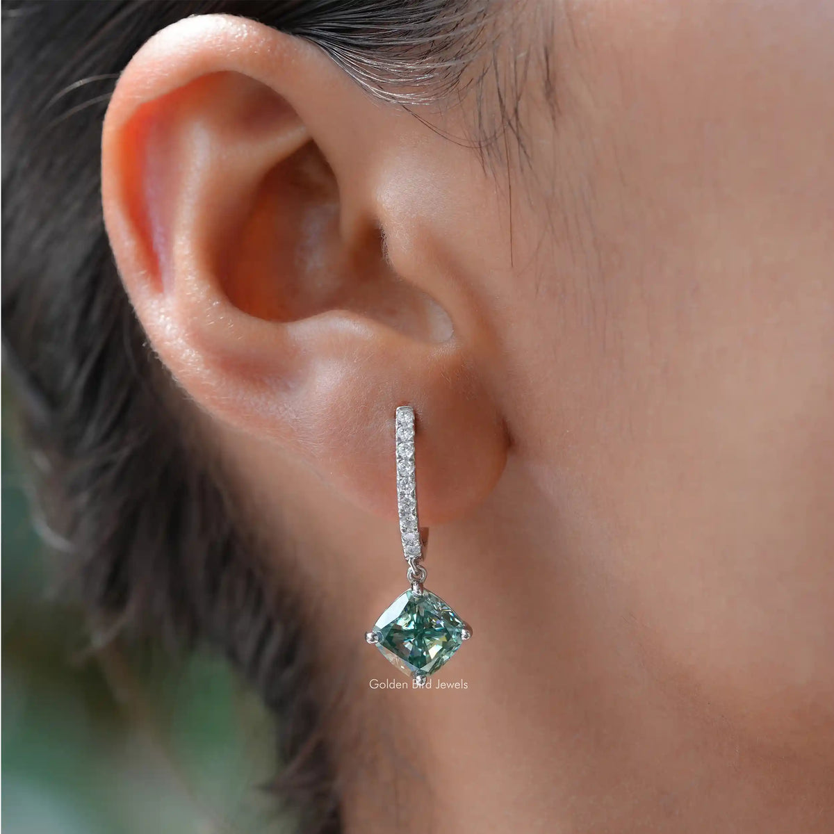 Drop dangle earrings with a green-blue cushion-cut gemstone and silver halo accents
