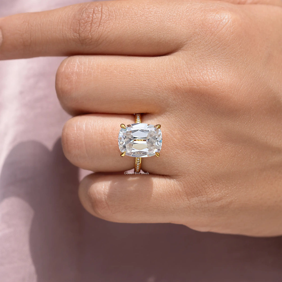Sterling silver engagement ring with cushion-cut center stone on a hand