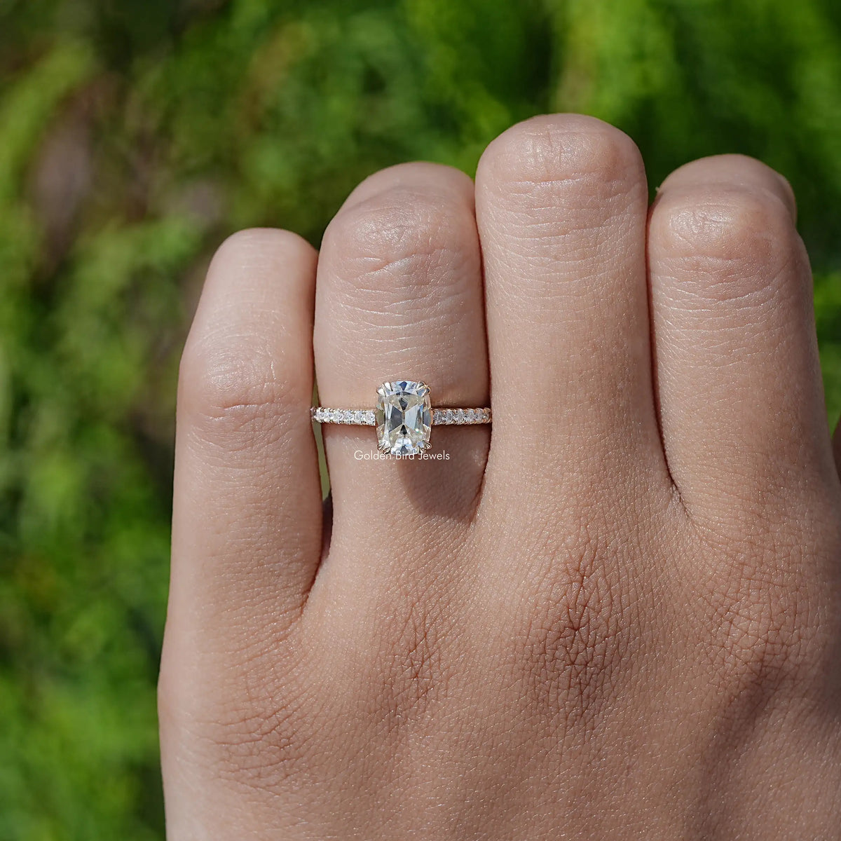 Elongated cushion cut moissanite ring with pavé band on a hand