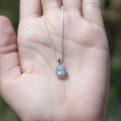 In Hand Showing of Cushion Cut Diamond Halo Necklace In White Gold