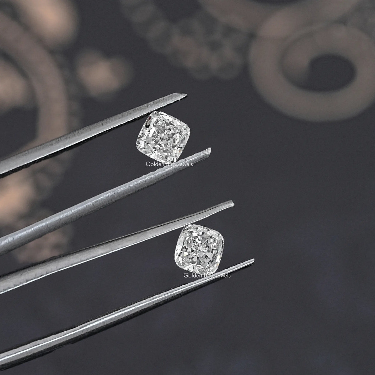 Cushion-cut lab grown diamond studs in tweezers, two matching stones