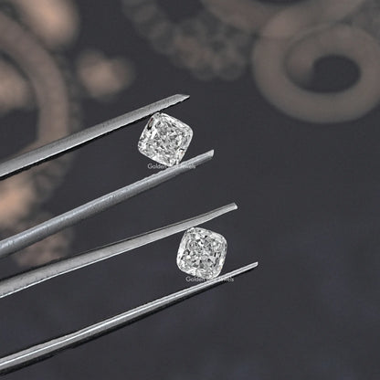 Cushion-cut lab grown diamond studs in tweezers, two matching stones