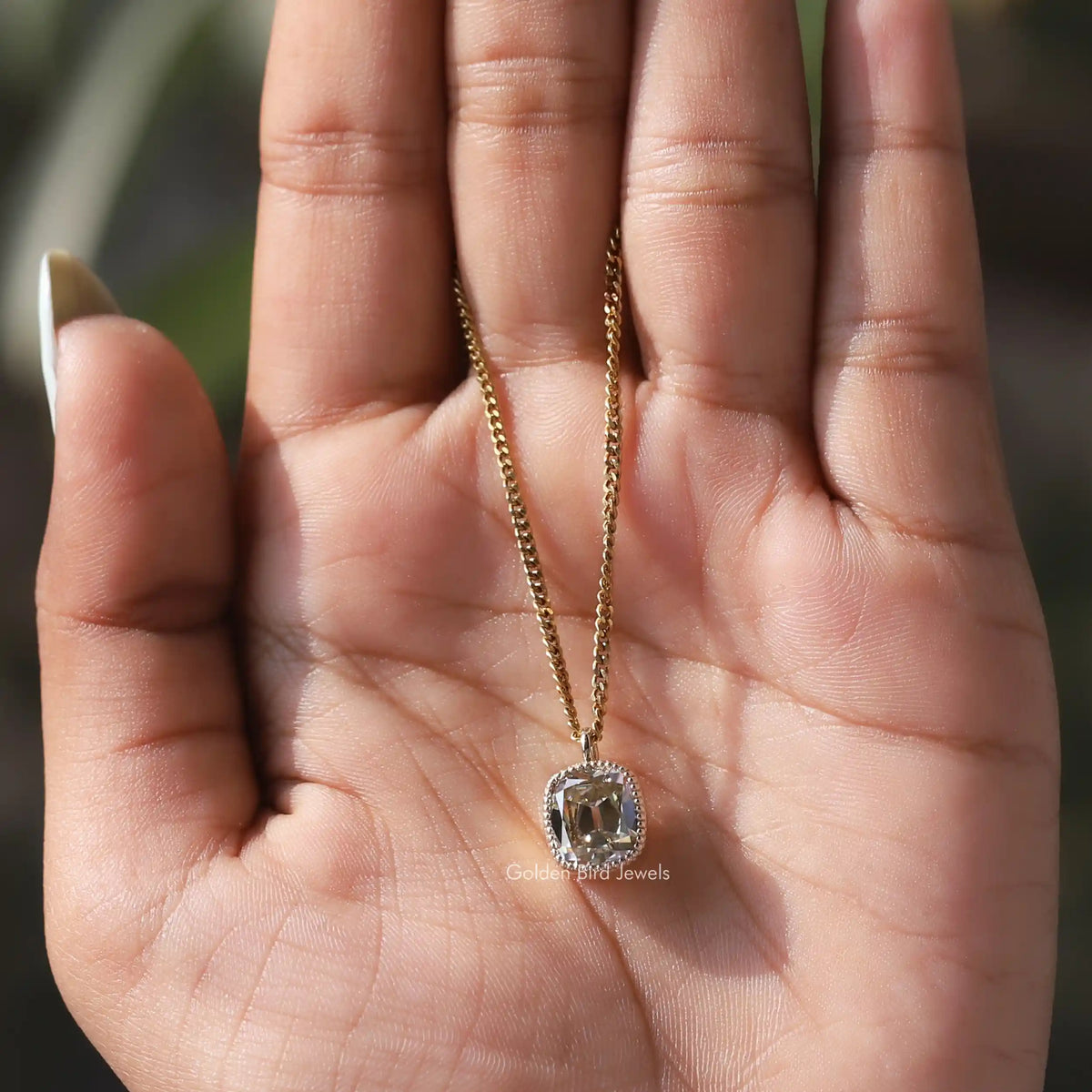 In hand showing view of moissanite pendant	 		