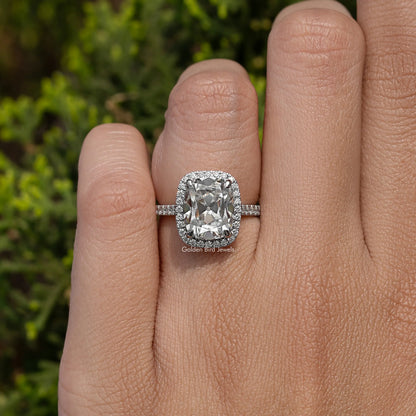 Halo cushion-cut moissanite engagement ring on finger, sterling silver band with side stones