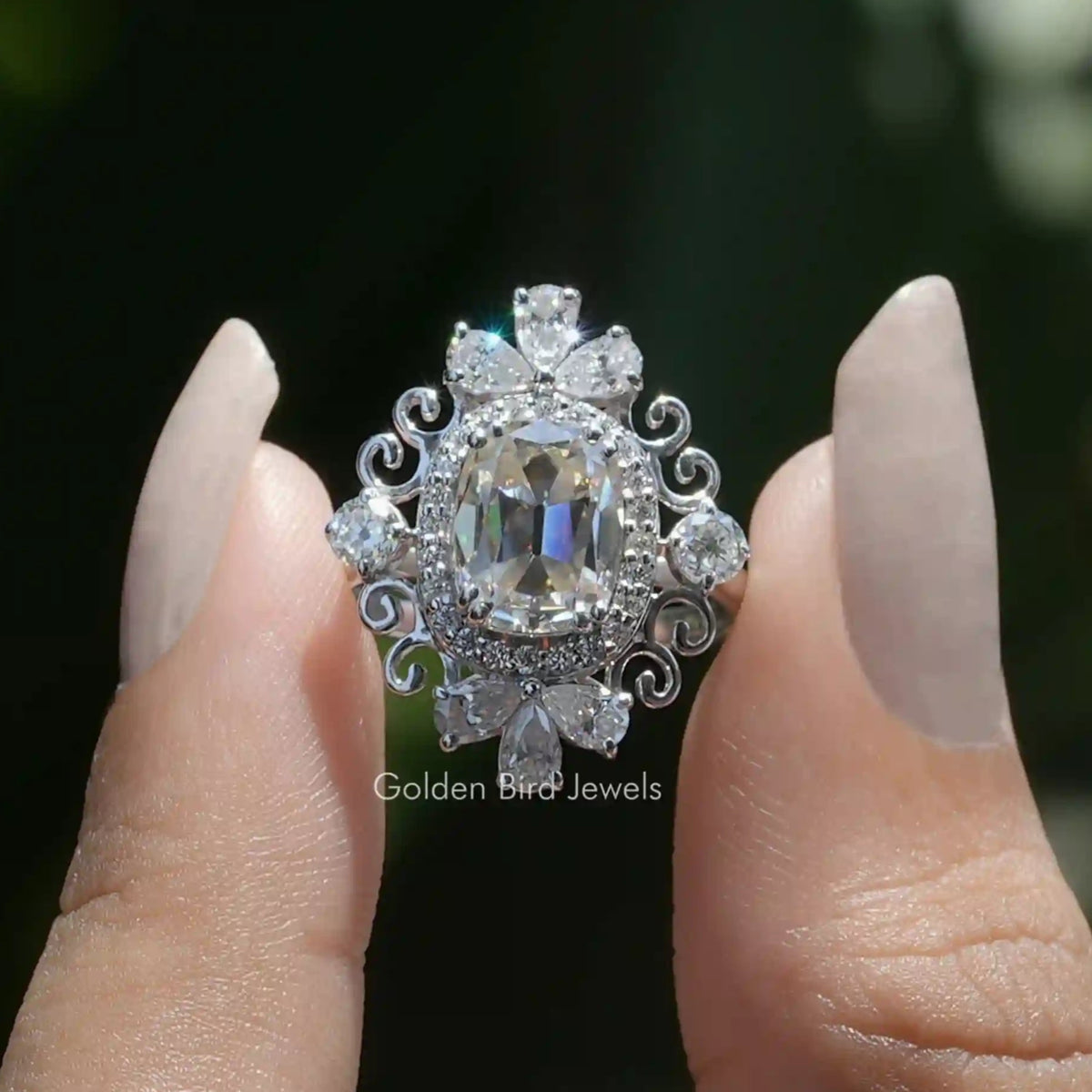 Vintage moissanite cushion-cut ring with halo, ornate silver scrollwork.