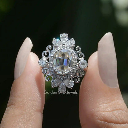 Vintage moissanite cushion-cut ring with halo, ornate silver scrollwork.