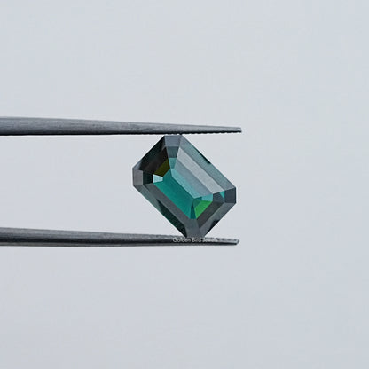 Loose emerald-cut dark green moissanite gemstone, angled view with crisp facets