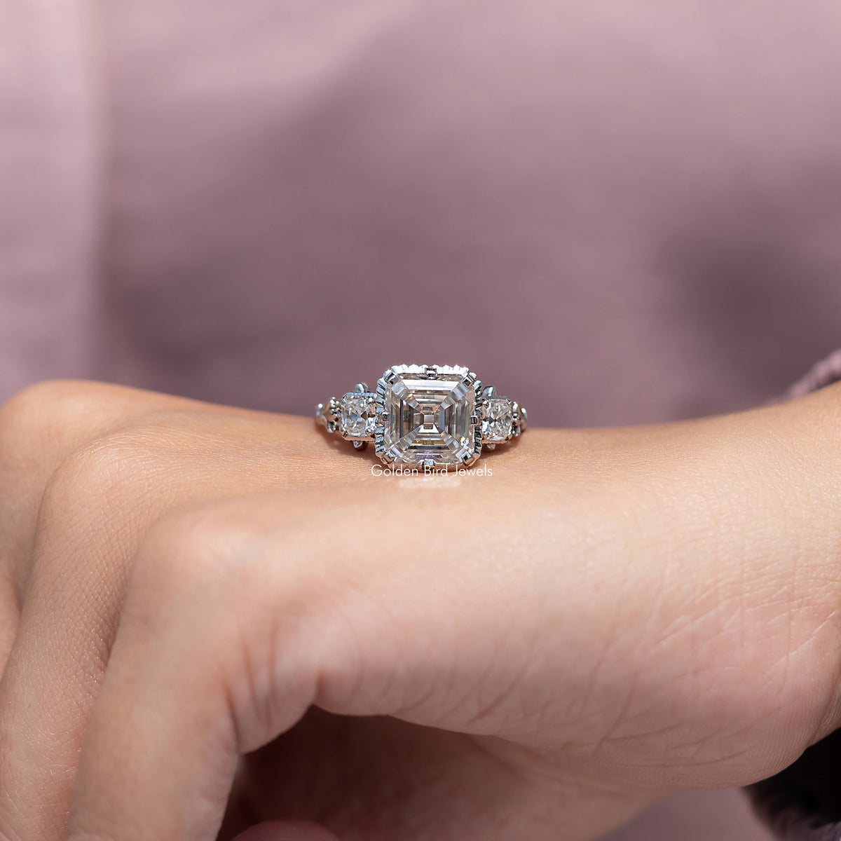 Three-stone moissanite ring with Asscher-cut center and clustered side stones