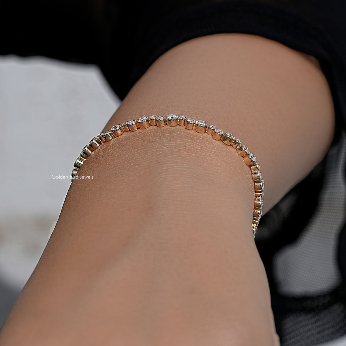 Gold-tone tennis bracelet with bezel-set round lab diamond row, side view