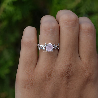Rose quartz leaf-style ring with silver band, close-up on hand