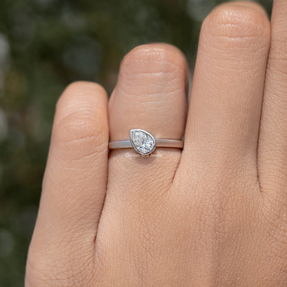 Slim silver band solitaire ring with bezel-set pear-shaped diamond, front view