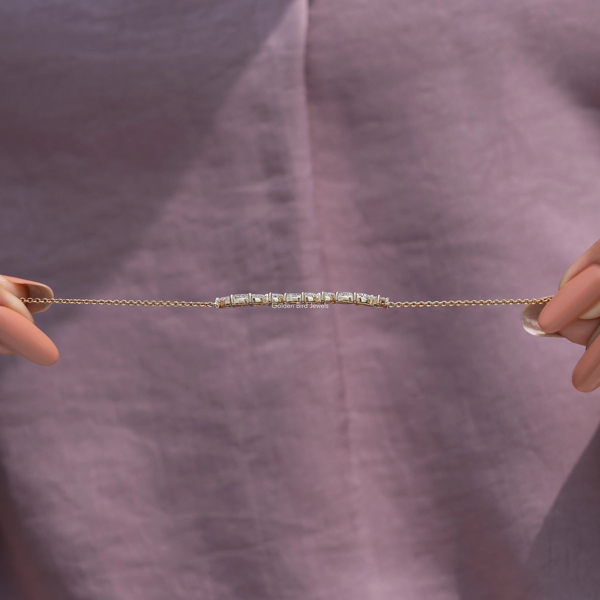 Gold lab-grown diamond line bracelet laid flat, sparkling marquise-cut stones