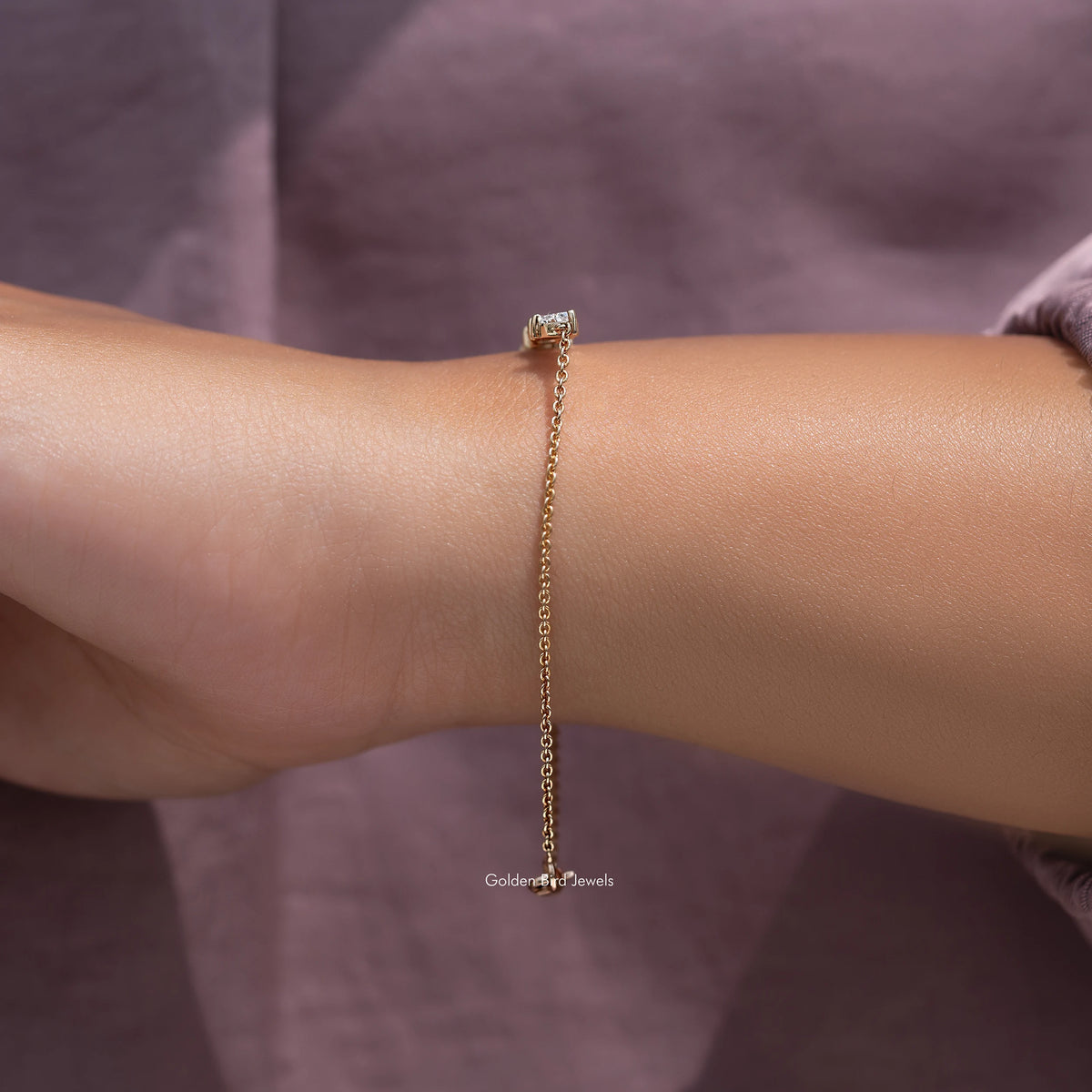 Gold lab-grown diamond line bracelet on wrist with small stone cluster at top