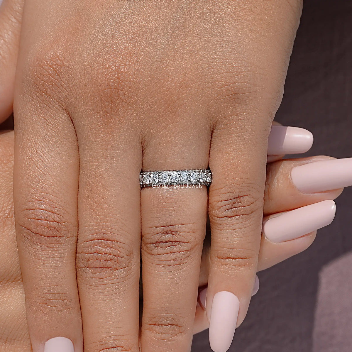 Moissanite eternity band on finger with round pavé stones